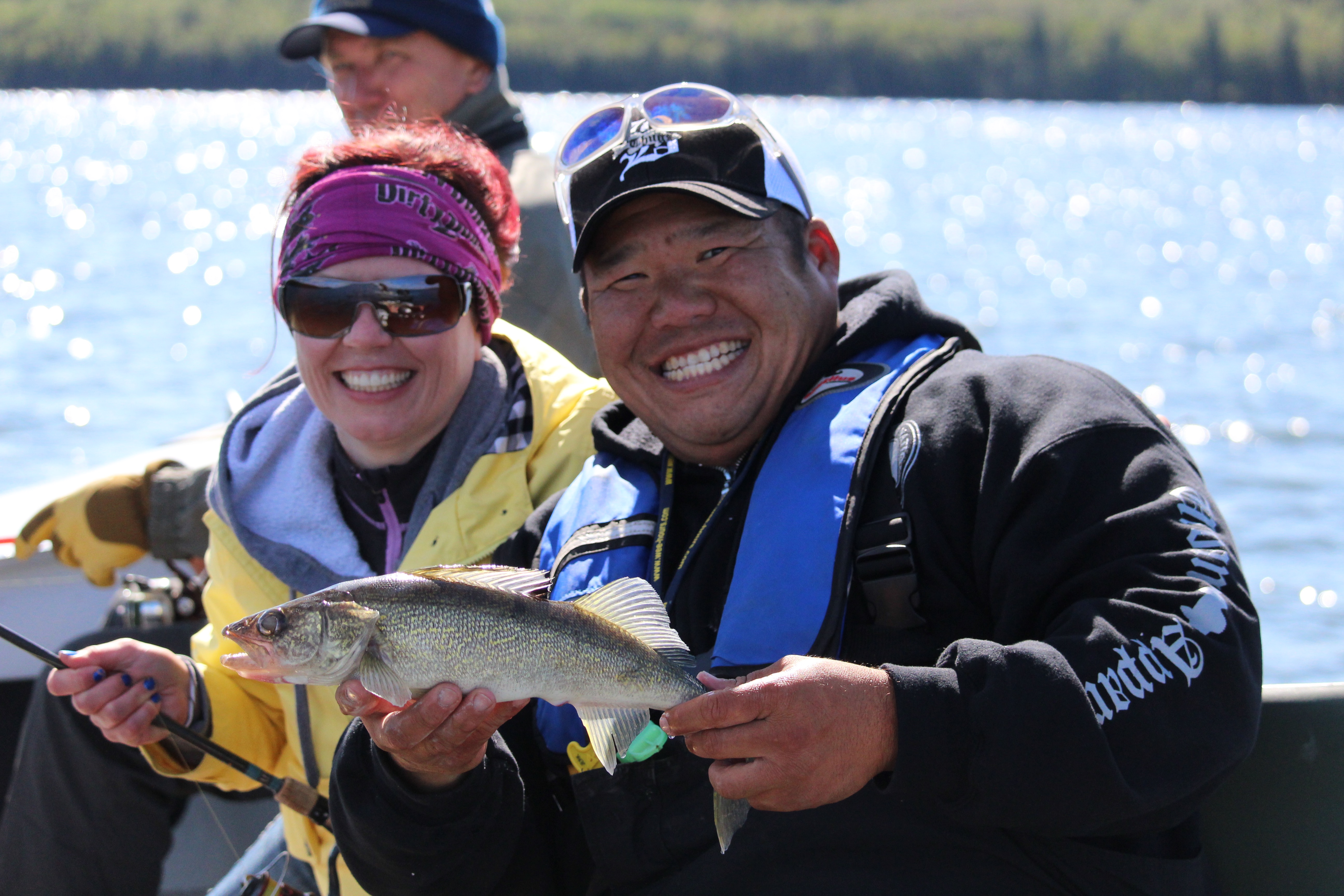 two people in a boat holding a fish